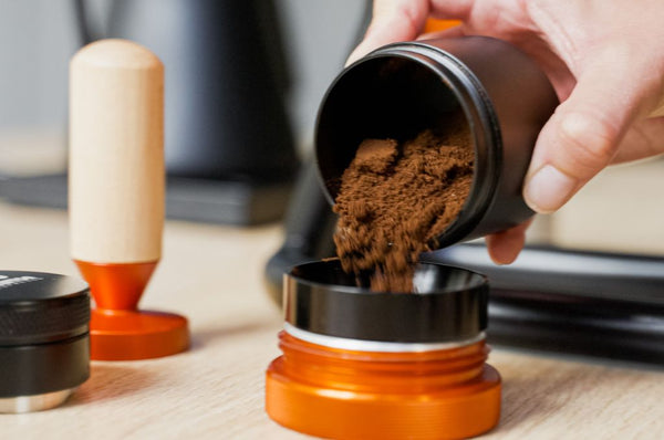 Adding fresh coffee grind to coffee basket
