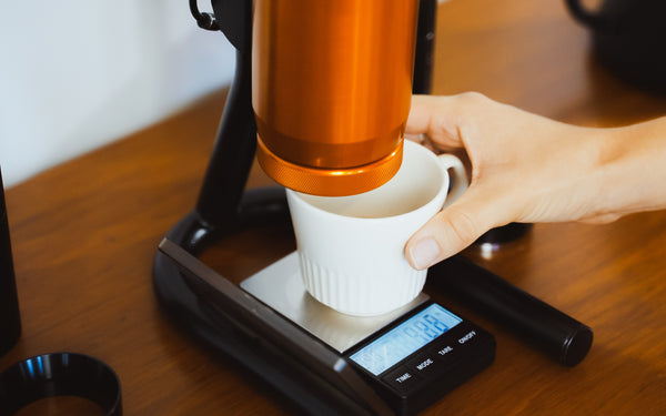 Weighing espresso coffee using digital scales to calculate brew ratio