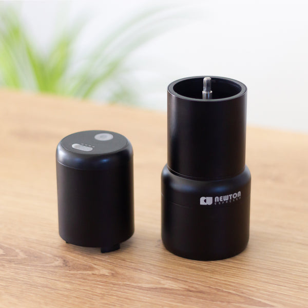 USB rechargeable portable coffee grinder sitting on wodden bench.
