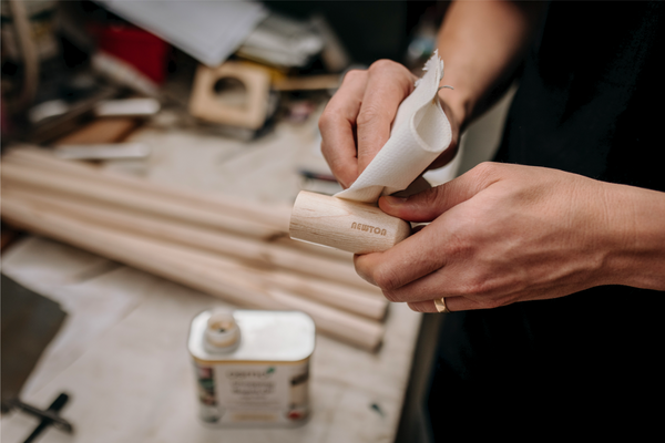 Oiling coffee maker wooden handle in workshop