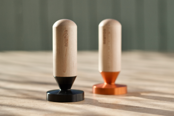 Newton Brua coffee tampers sitting on wooden table