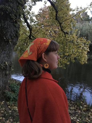 Faith looking out towards a river wearing an orange headscarf