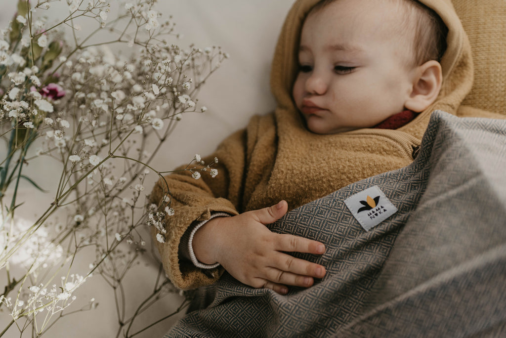 Baby kuschelt mit Tragetuch von Mama Nuka