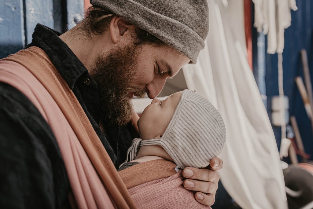 Papa und Baby schmusen im Tragetuch von Mama Nuka