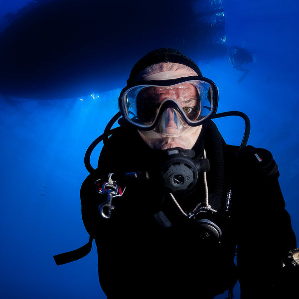 Photo of Scuba Diver Photographer diving under boat