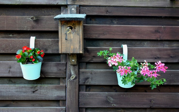 Clôture avec pots de fleurs suspendus envahis par les fleurs