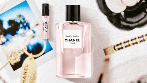 Två CHANEL-parfymflaskor i en rosa nyans framträder mot en bakgrund med suddiga modeillustrationer och accessoarer.