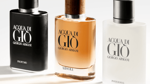 Tre parfymflaskor från Giorgio Armani's ACQUA DI GIÒ-serie, inklusive "PROFUMO" i svart, "ABSOLU" i gyllenbrun och "POUR HOMME" i vit, alla med tydlig märkning på en ljus bakgrund.
