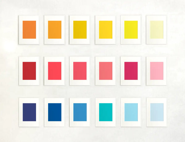 A gallery of framed paint swatches featuring various shades of yellow, red, and blue