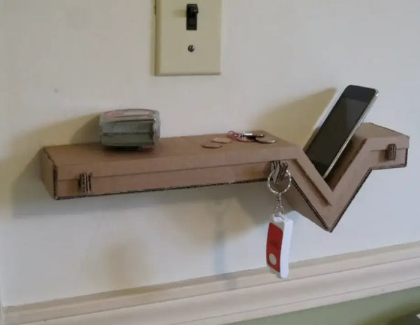 Floating cardboard wall shelf with a cellphone, keys, and other items