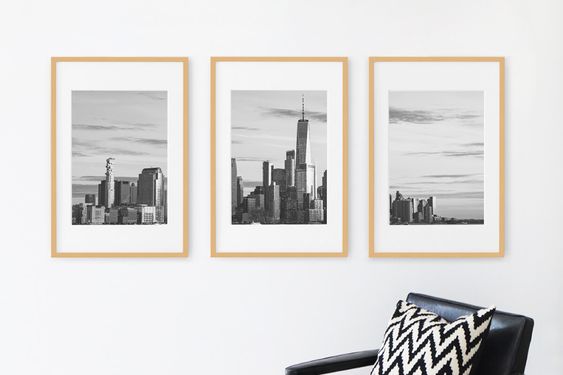 a gallery frame of three black and white skyline photos framed in wooden hanging frames