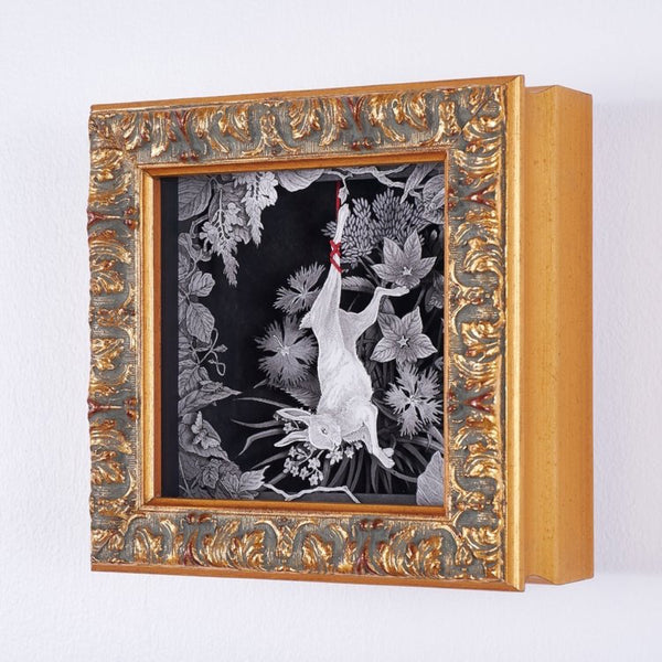 An ornate deep-set frame or a shadow box with framed art