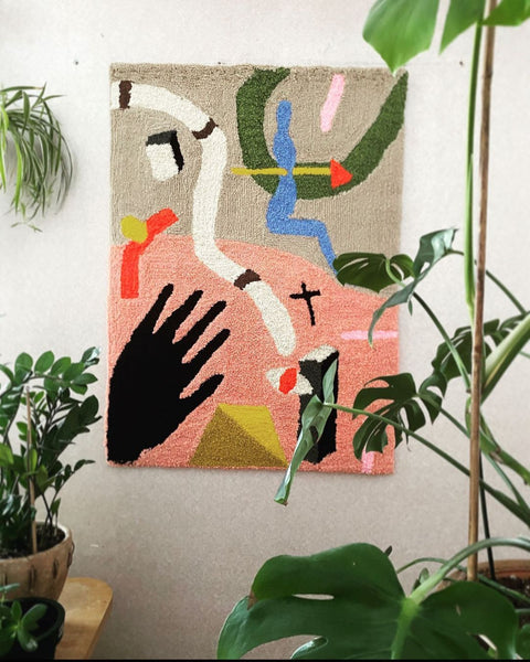 A tufted wall tapestry on a wall with plant room decor