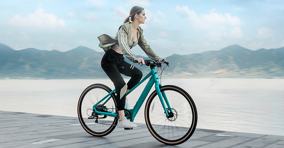 Donna che guida la bici elettrica in riva al lago