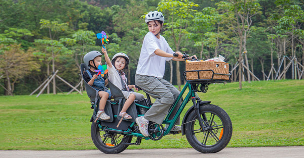 Woman riding an electric bicycle carrying two children