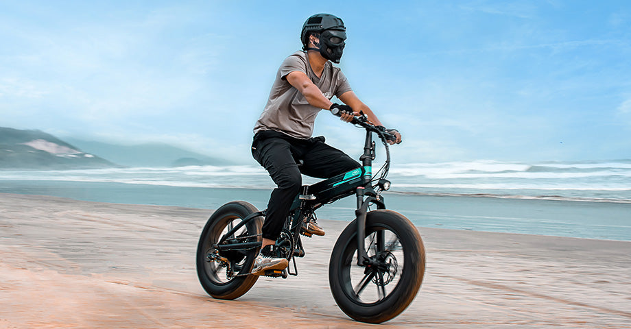 Mann fährt Fiido M1 Pro Fat Tire Elektrofahrrad am Strand