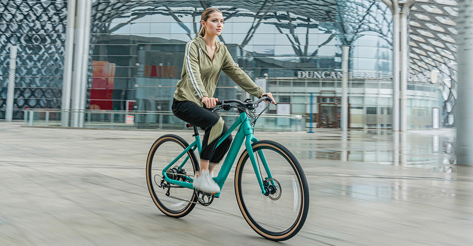 Donna che guida una bici elettrica per fare shopping