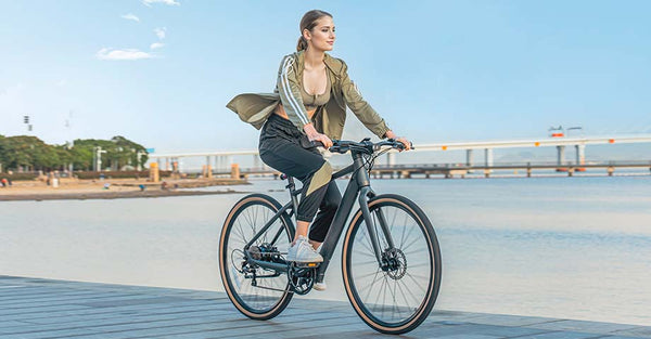 Woman riding electric bike by lake