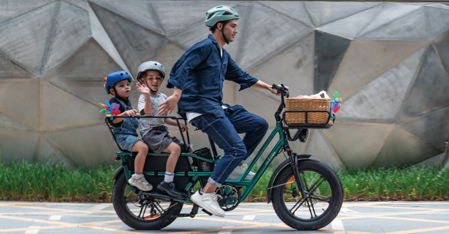 Man riding fiido t2 electric bicycle carrying two children