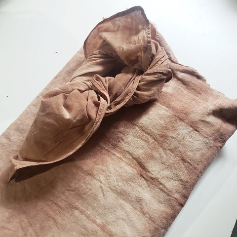 pinky brown fabric folded up on a white table top