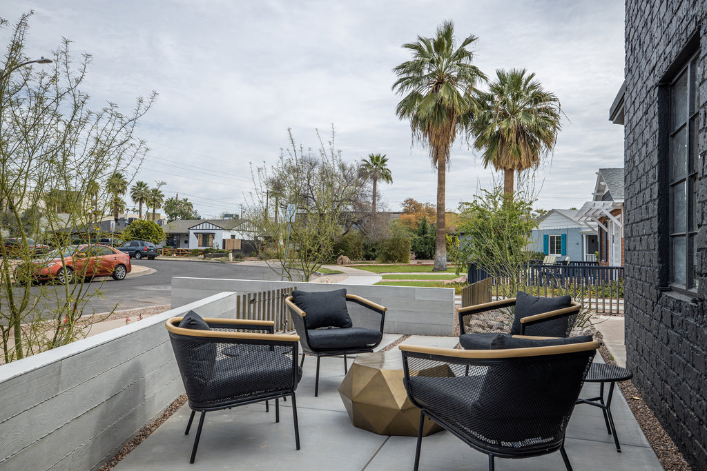 James Judge courthard featuring black outdoor furniture and a bronze angular outdoor table and concrete board formed panels 