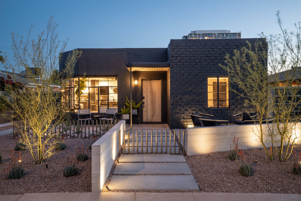 James Judge Home transformation showing exterior of house painted black with Wall Theory Board-Form Panels used on courtyard wall