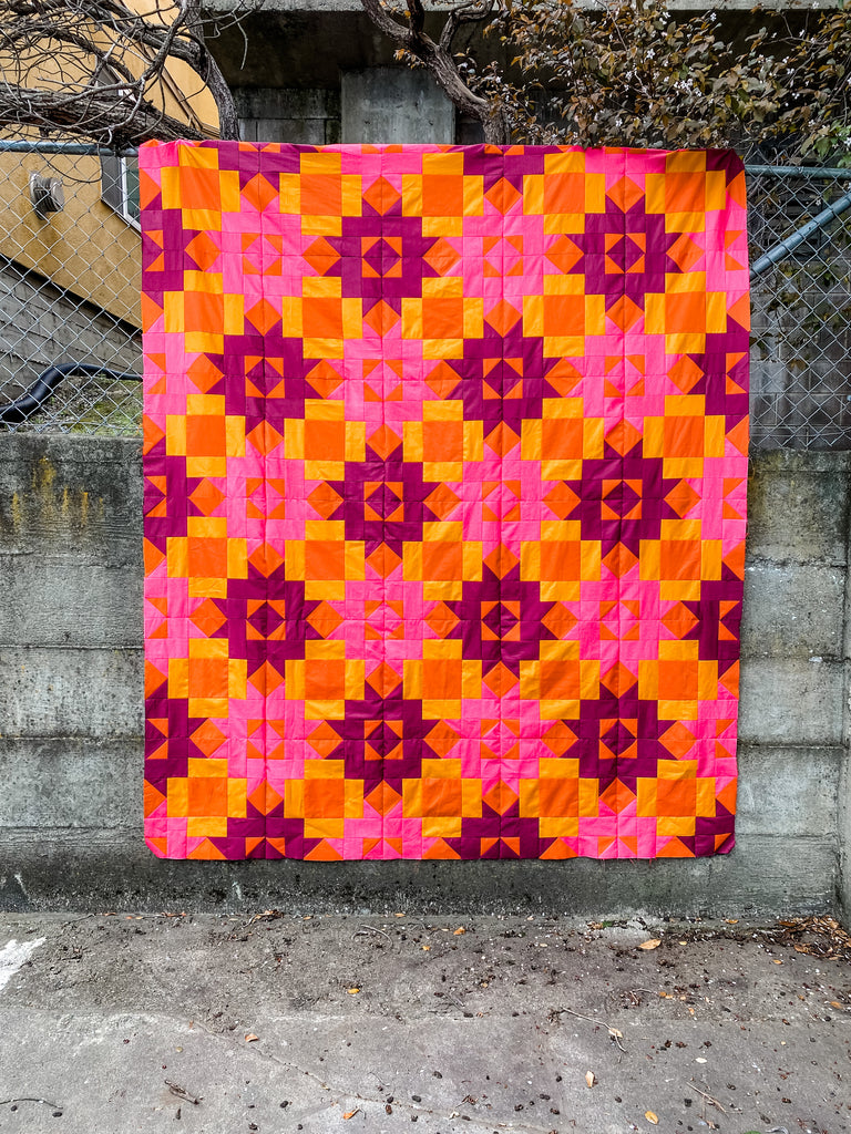 Petal Points quilt top in pink and orange. 