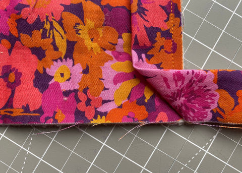 Pull binding away from the corner, creating a 45 degree fold. 