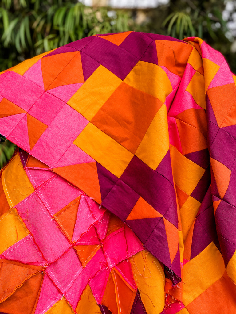 Quilt top in hot pink, wine, rust and bright orange. 