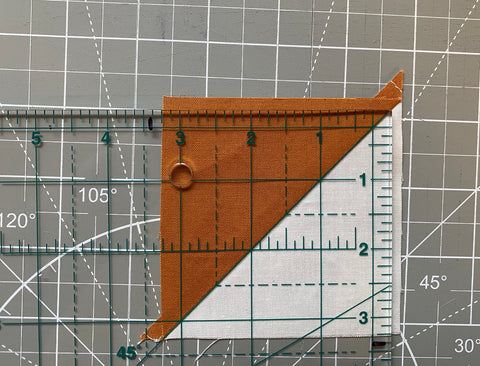 Lining up a square ruler over a HST block