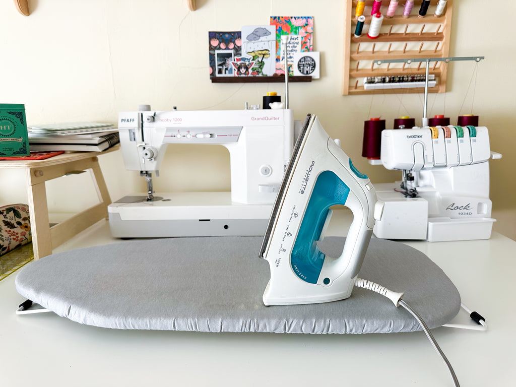 small space pressing station - mini ironing board and iron on sewing table
