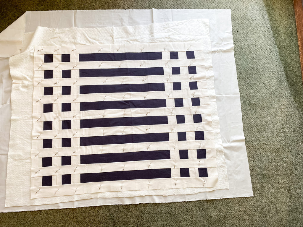 how to baste a quilt - simple stripes quilt - fully basted quilt on the floor