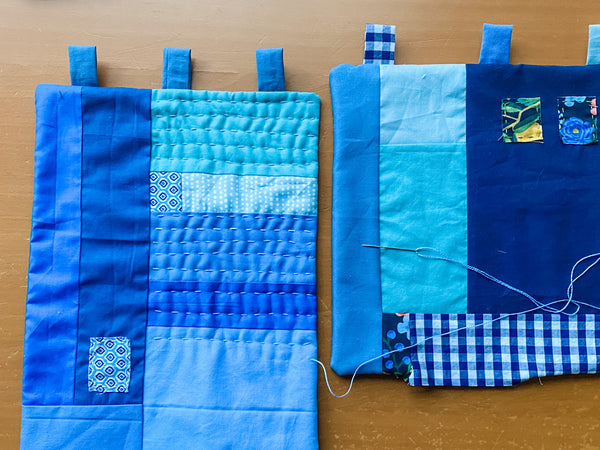 two improv quilted wall hangings in blue