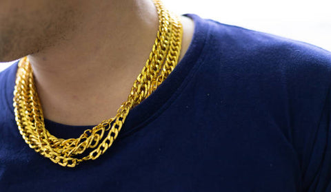 un homme porte de nombreuses chaînes en or