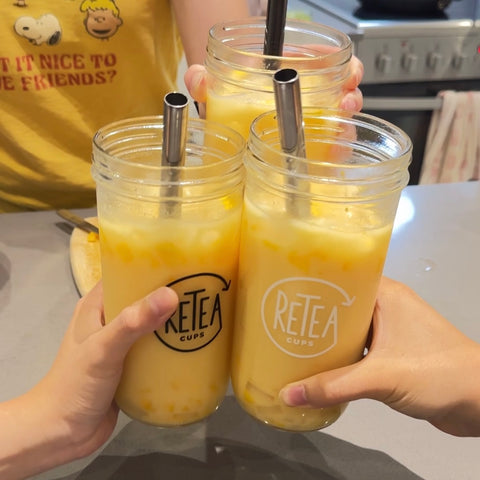 Four mango milk teas in reusable glass boba cups