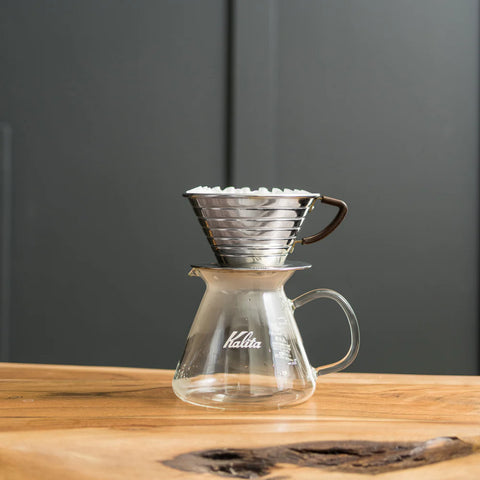 Stainless steel Kalita Wave brewer sitting on top of a Kalita glass server