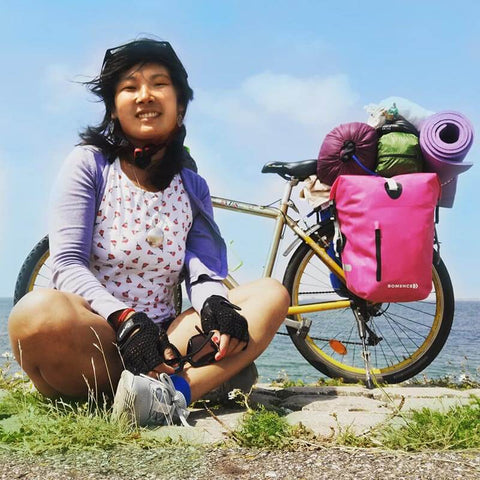 Gevoel van vrijheid, bikepackende vrouw zee op de achtergrond, roze fietstas tijdens het reizen, vrouw gaat op fietstocht, bepakt voor de mountainbike zitten, fietstocht Holland blog, Bomence Style