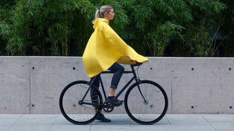 gele regenponcho voor damesfiets