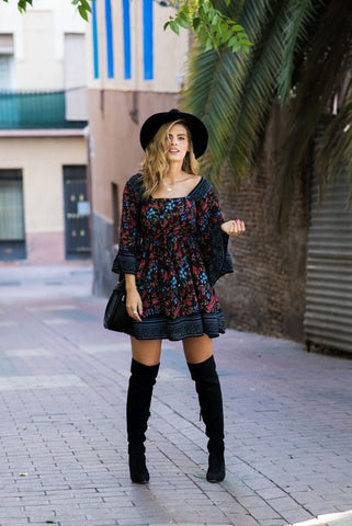 Floral dress, a pair of knee-high boots, and a dark hat