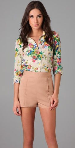 Floral shirt tucked in to a pair of shorts