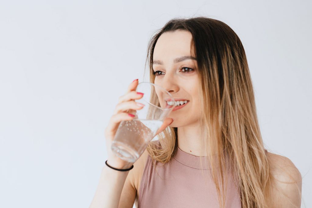 Woman drinking water smiling