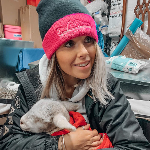Dannielle holding a lamb in her arms.