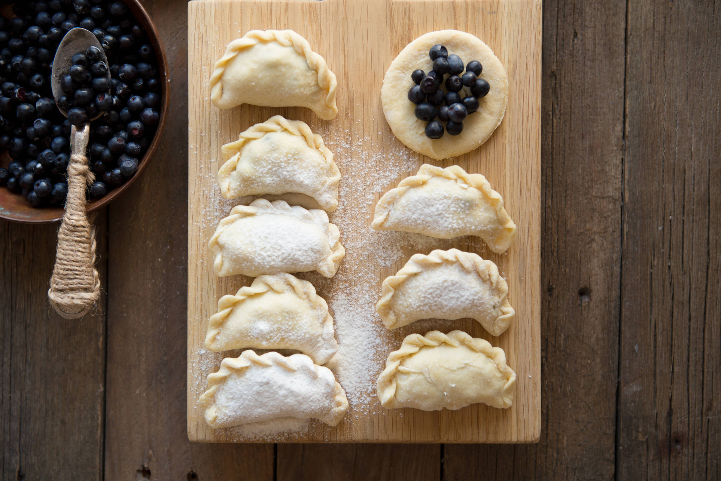 Blueberry dumplings on a wooden board.