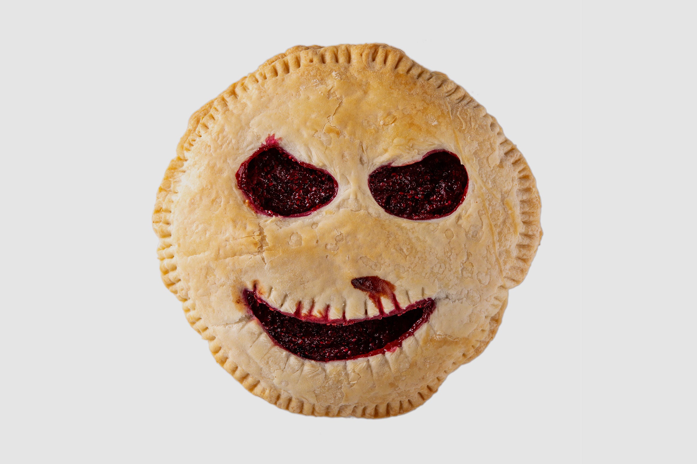 Halloween fruit pie with creepy face cut out of the pie top.
