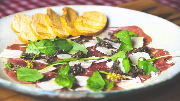 Veal carpaccio served with parmesan, arugula, aged mustard and tartufata truffle sauce