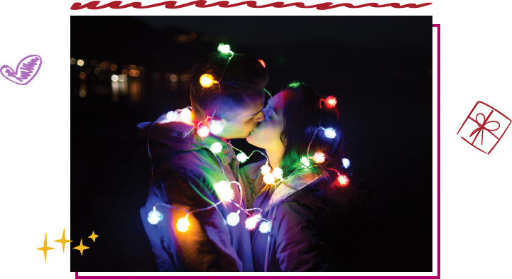 Kissing couple wrapped in holiday light