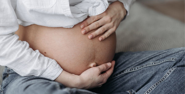 Pregnant person holding their bump