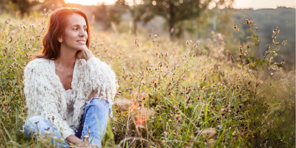 Relaxed menopausal woman sat in field