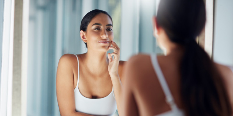 Natural woman reflecting in mirror