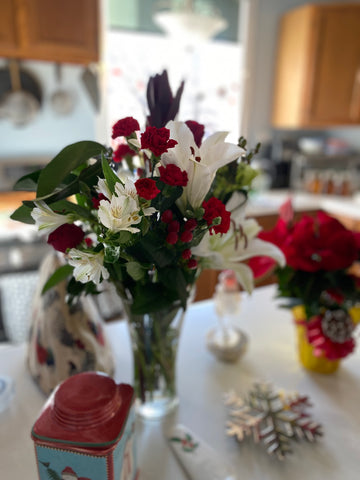 a bouquet of red and white flowers in a vase